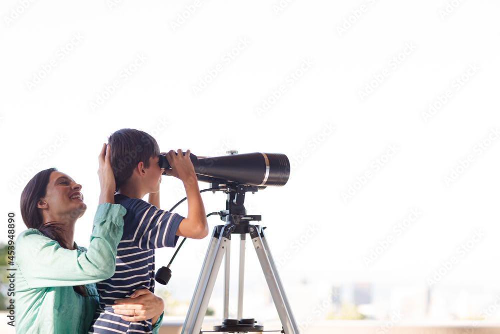 Mother and son using telescope