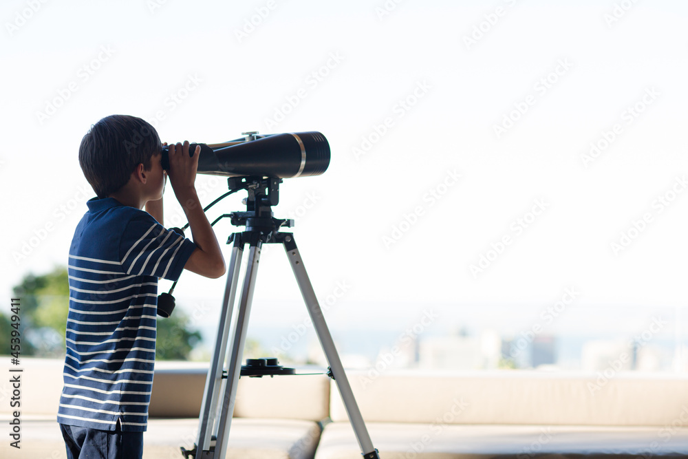 Boy using telescope outdoors