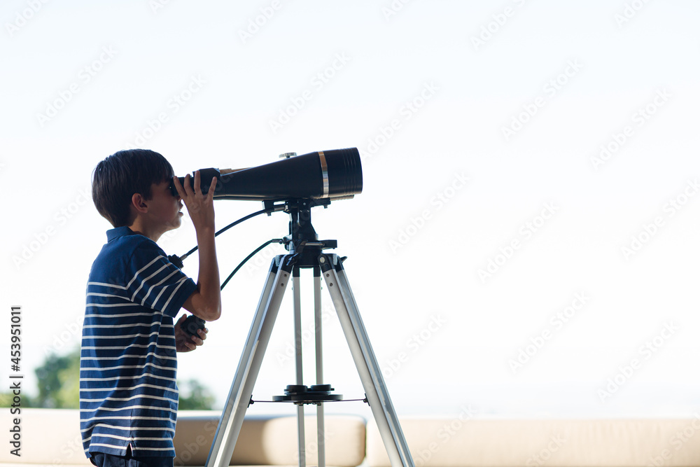 Boy using telescope outdoors
