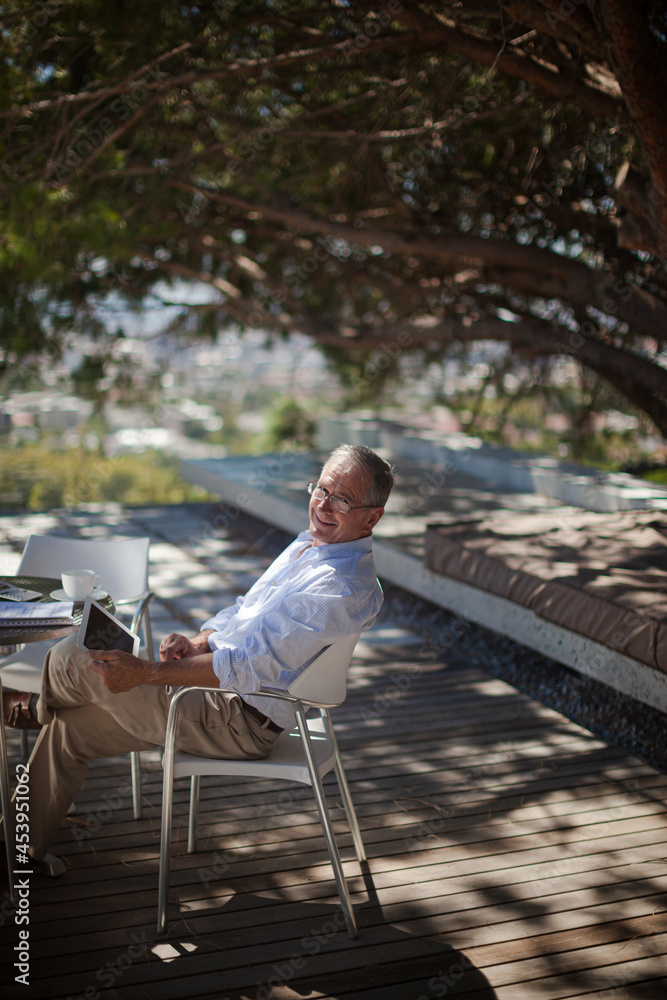 Older man using tablet computer outdoors Older man using tablet computer outdoors