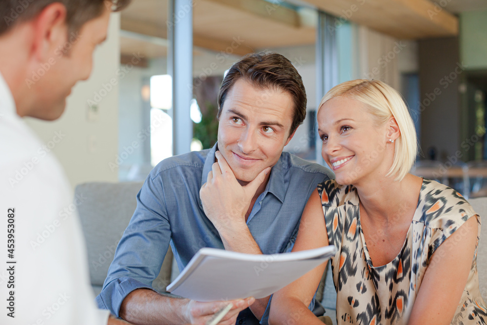 Financial advisor talking to couple on sofa