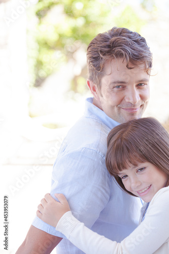 Father and daughter hugging outdoors © KOTO