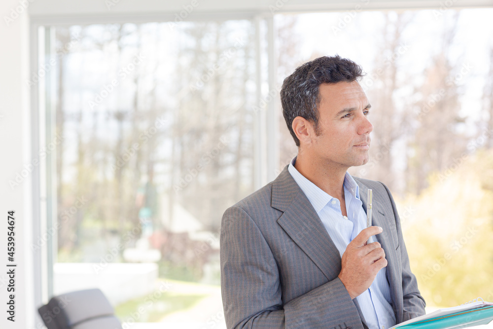 Businessman standing at office window Businessman standing at office window