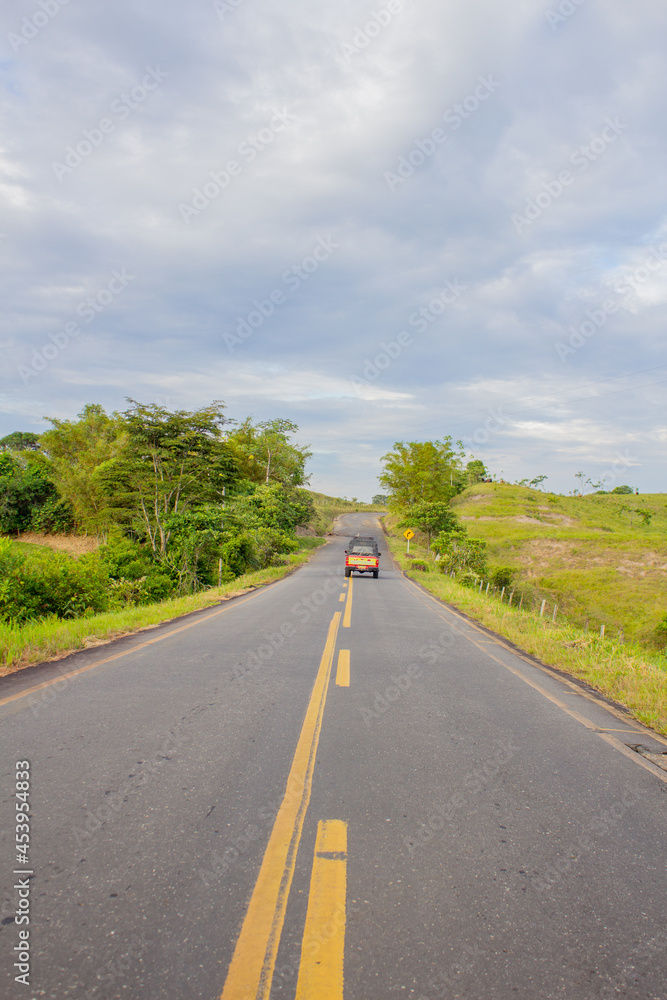 red car on the road in a colombian countryside