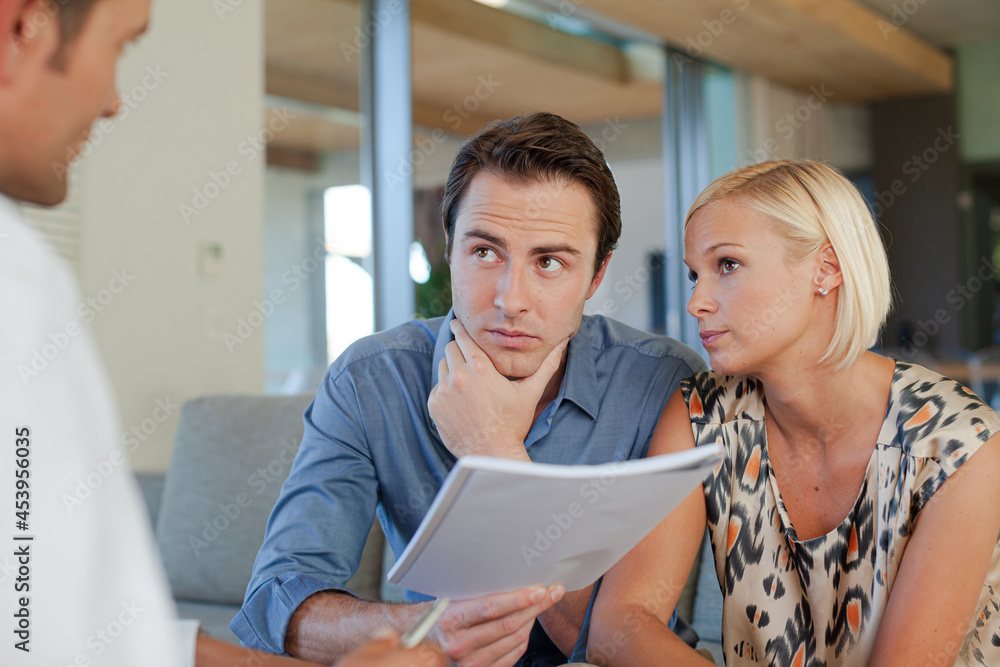 Financial advisor talking to couple on sofa Financial advisor talking to couple on sofa
