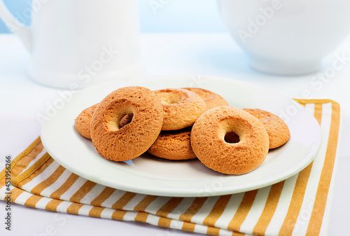 rosquinhas de nata, tipo biscoitos, no prato em fundo de mesa decorada. photo