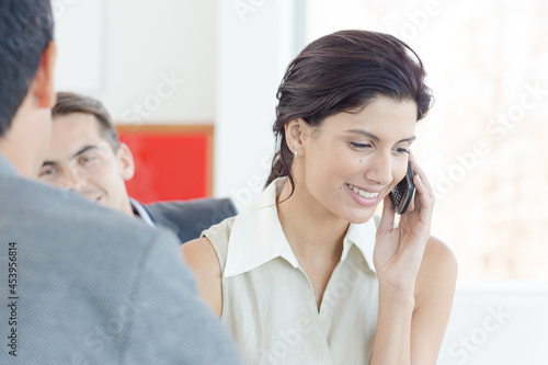 Businesswoman talking on cell phone in office