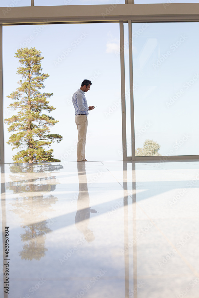 Businessman standing at office window Businessman standing at office window