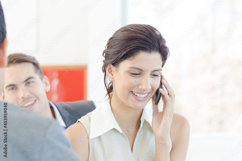 Businesswoman talking on cell phone in office Businesswoman talking on cell phone in office