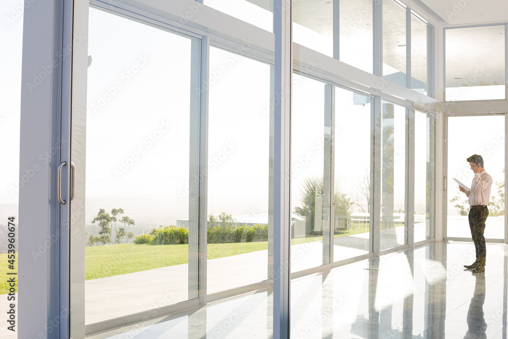 Businessman standing at office window Businessman standing at office window