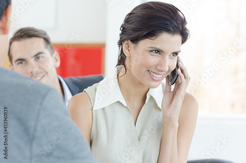 Businesswoman talking on cell phone in office