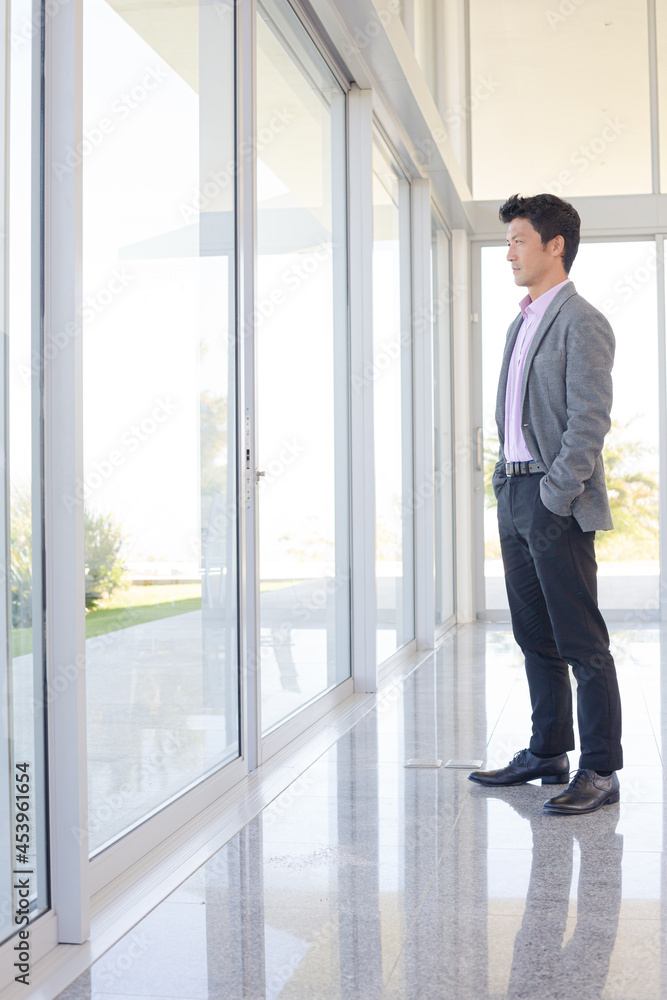 Businessman standing at office window Businessman standing at office window