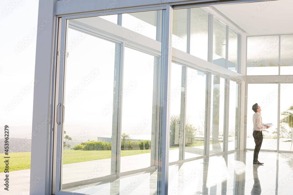 Businessman standing at office window Businessman standing at office window