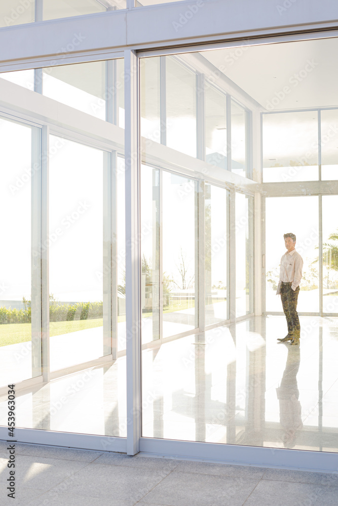 Businessman standing at office window Businessman standing at office window