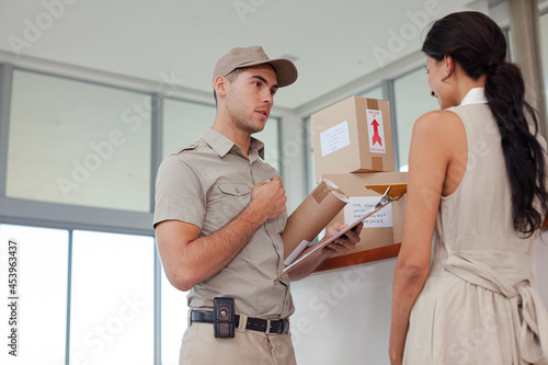 Woman signing for packages from delivery boy © KOTO