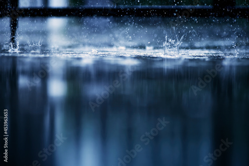heavy raining make many small splash crown from water droplets drop down to the concrete floor in blue tone color scene