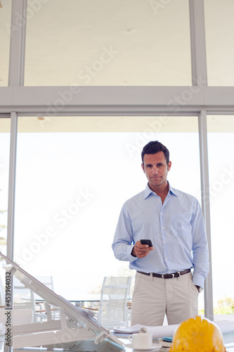 Businessman using cell phone in office © KOTO
