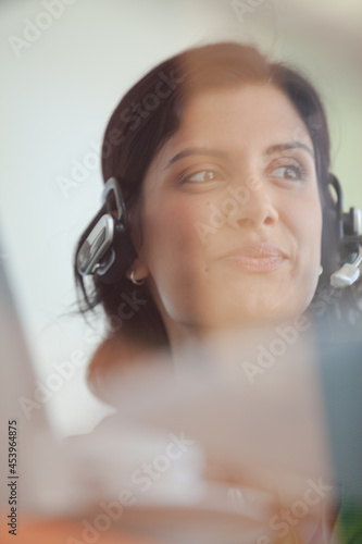 Businesswoman listening to headphones at desk