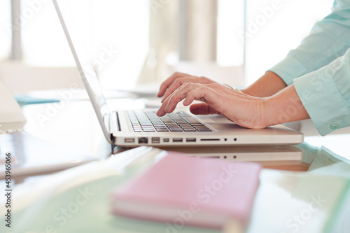 Businesswoman using laptop at desk © KOTO