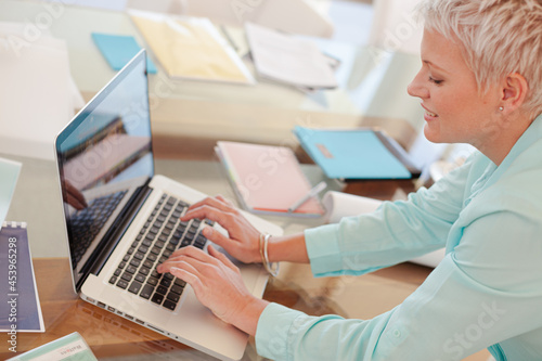 Businesswoman using laptop at desk