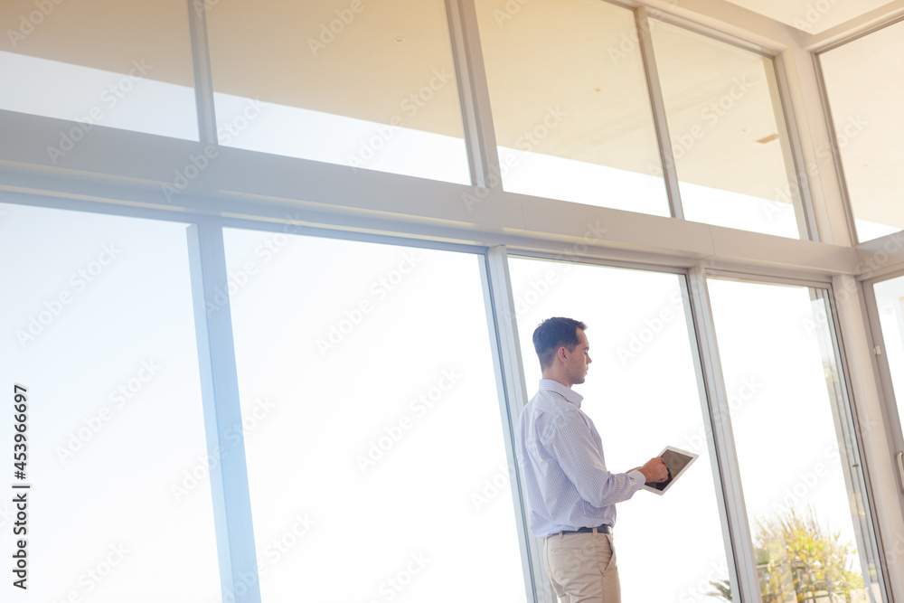 Businessman using tablet computer at window Businessman using tablet computer at window