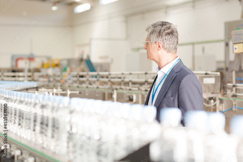 Businessman standing in bottling plant Businessman standing in bottling plant