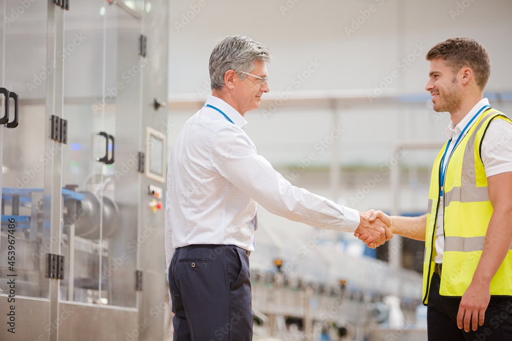 Obraz premium Supervisor and worker shaking hands in factory