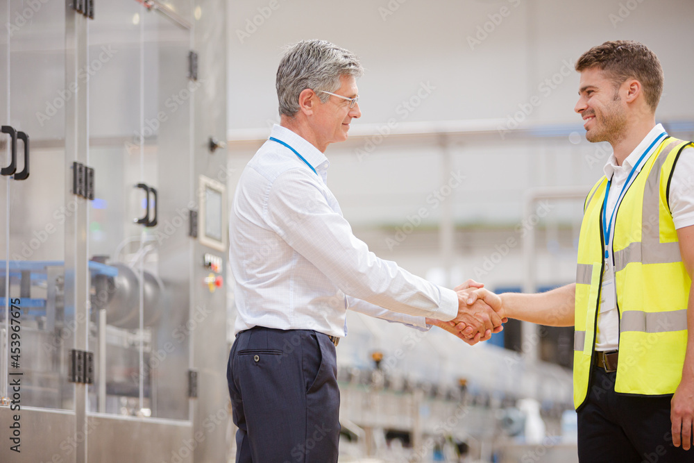 Obraz premium Supervisor and worker shaking hands in factory