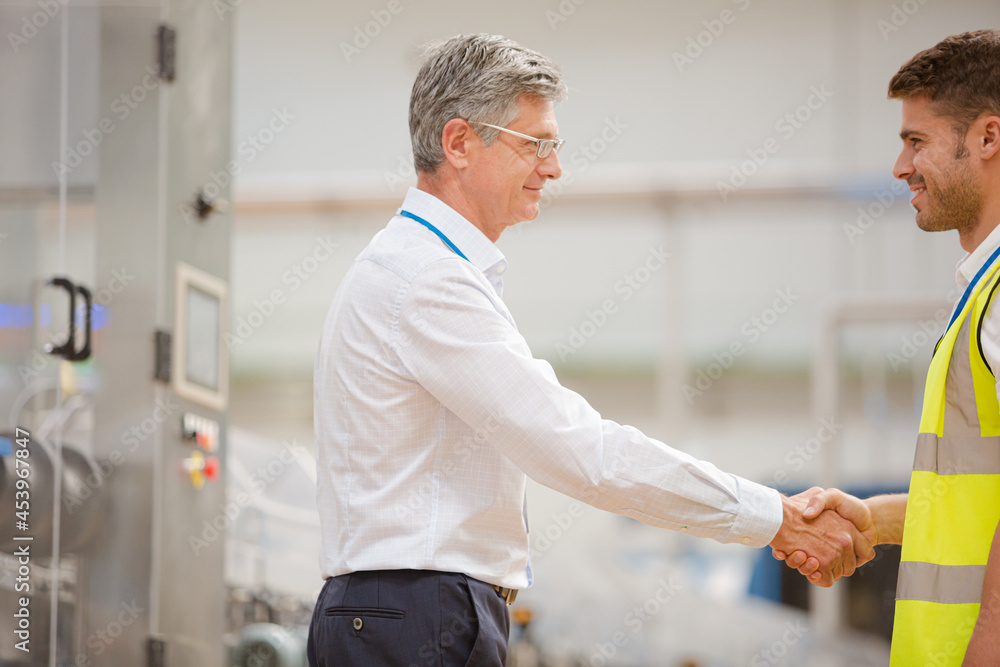 Obraz premium Supervisor and worker shaking hands in factory