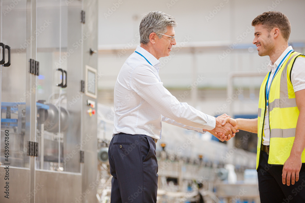 Fototapeta premium Supervisor and worker shaking hands in factory