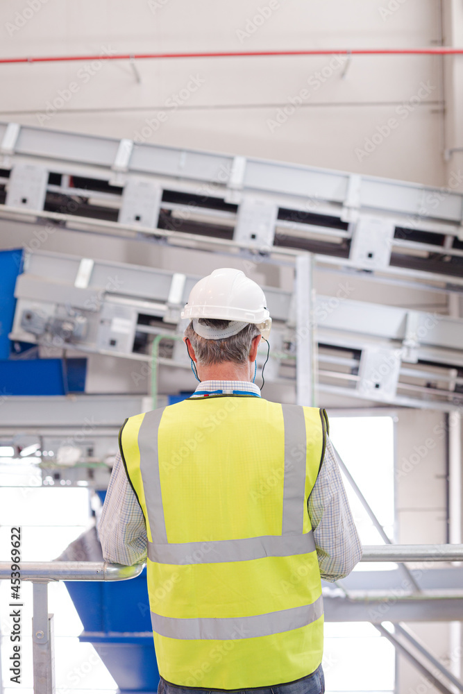 Worker on platform in recycling center Worker on platform in recycling center