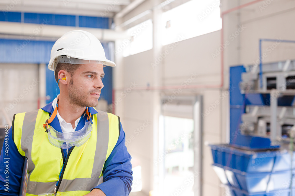 Worker wearing hard hat and ear plugs Worker wearing hard hat and ear plugs