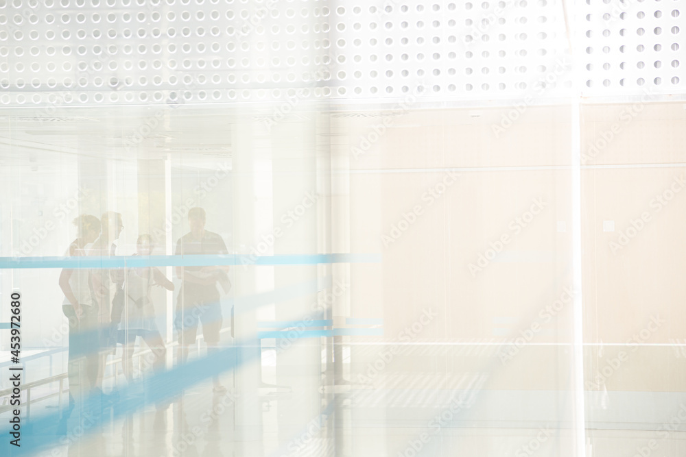 Fototapeta premium People standng in building behind glass