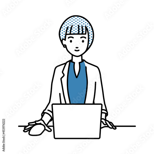デスクで座ってPCを使っているジャケットの女性
