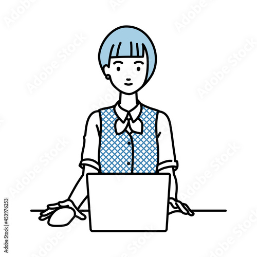 デスクで座ってPCを使っている事務員制服の女性