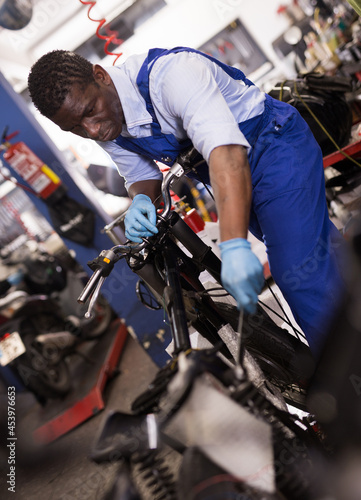 Service engineer repairs a motorcycle steering wheel in a motorcycle service. High quality photo