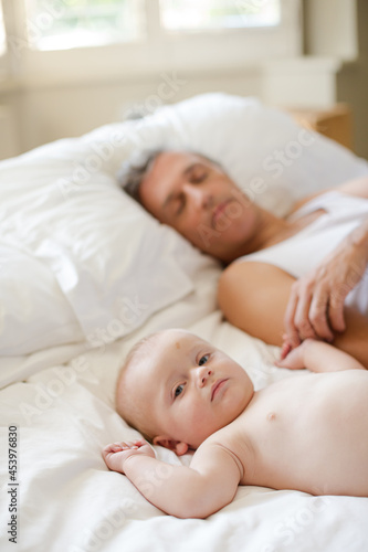 Father and baby laying on bed