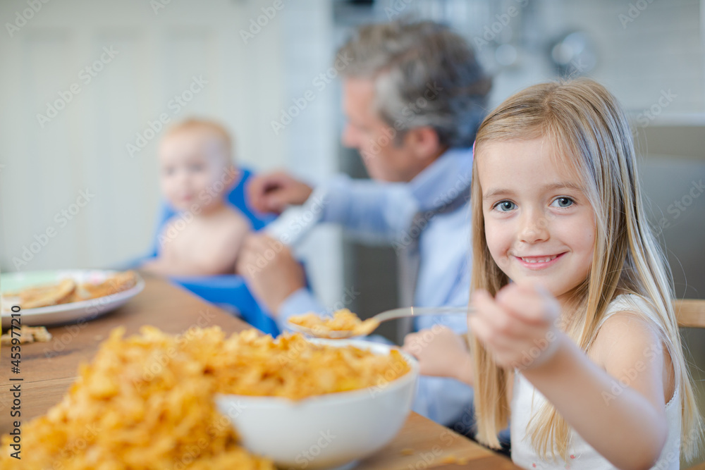 Girl eating overflowing bowl of cereal Girl eating overflowing bowl of cereal