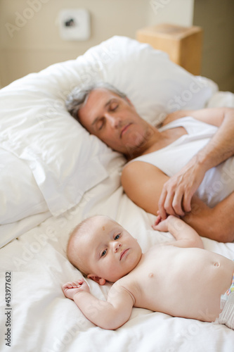 Father and baby laying on bed