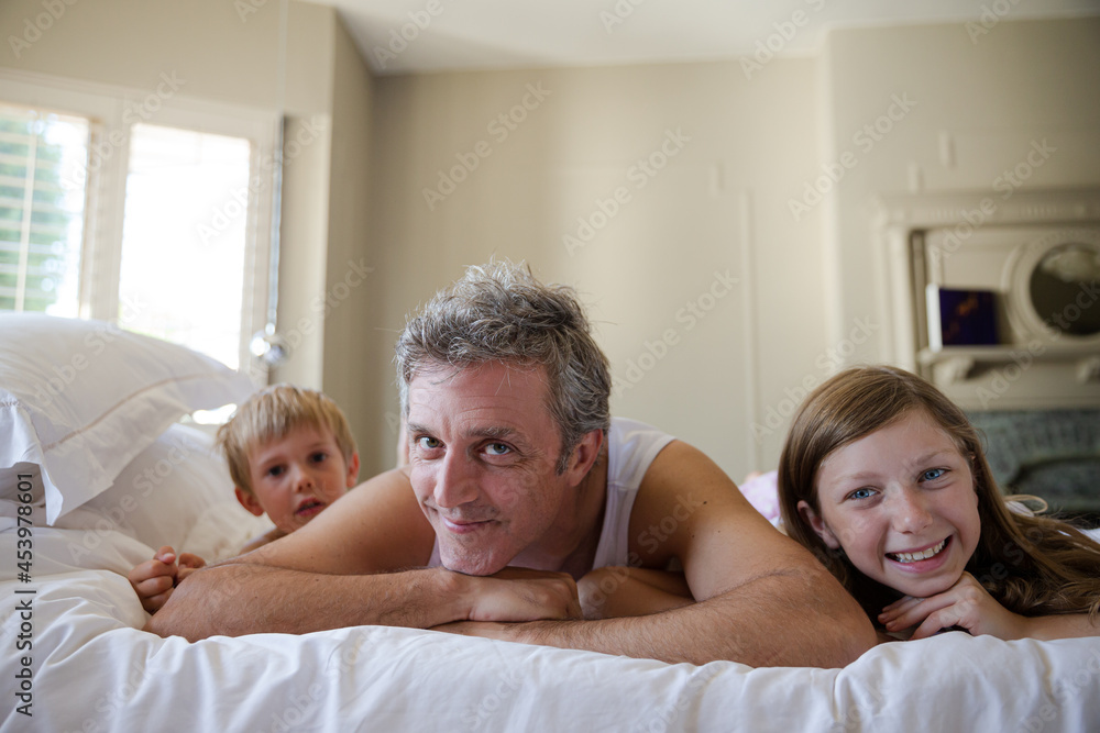 Father and children relaxing on bed Father and children relaxing on bed