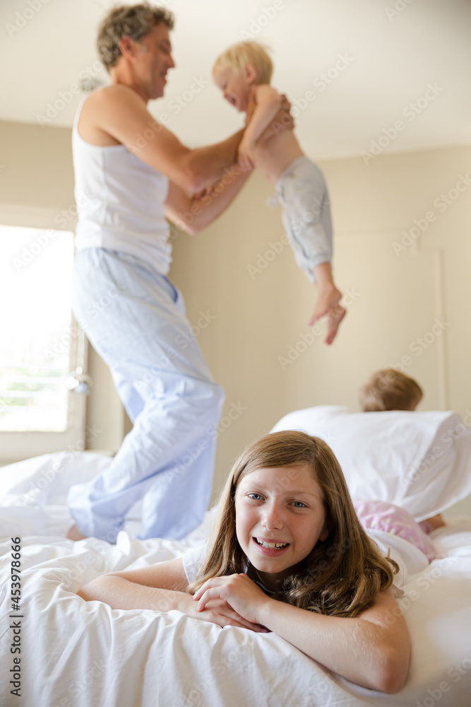 Fototapeta premium Smiling girl laying on bed