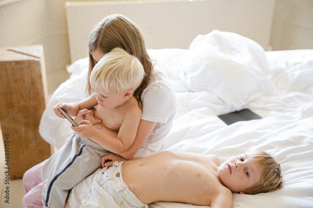 Children using cell phone together Children using cell phone together