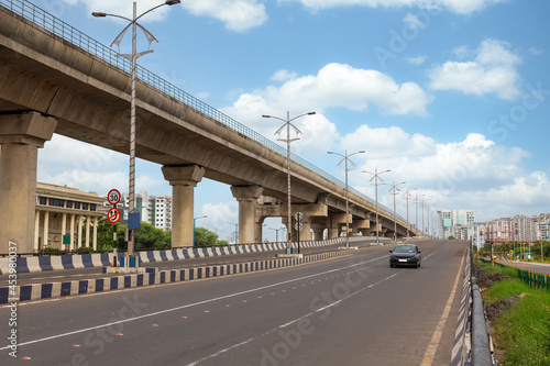 Early morning traffic on city road with view of flyover and commercial and residential buildings at Rajarhat area Kolkata photo