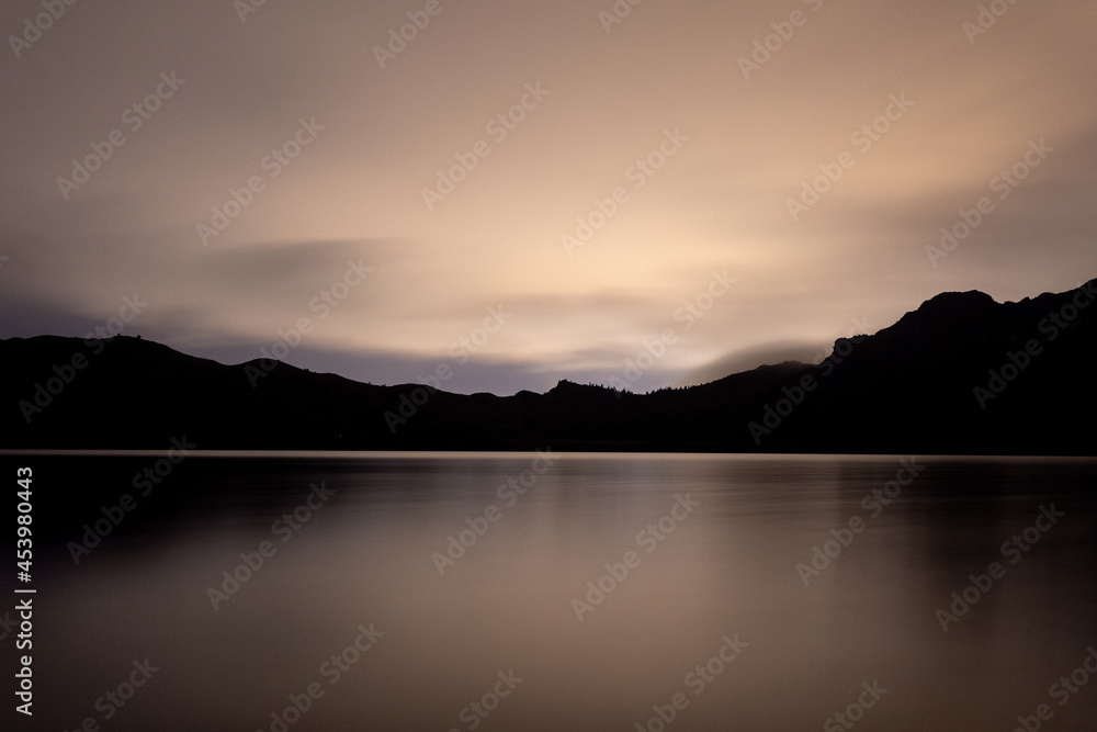 sunset over the lake mirror effect mountains silhouette