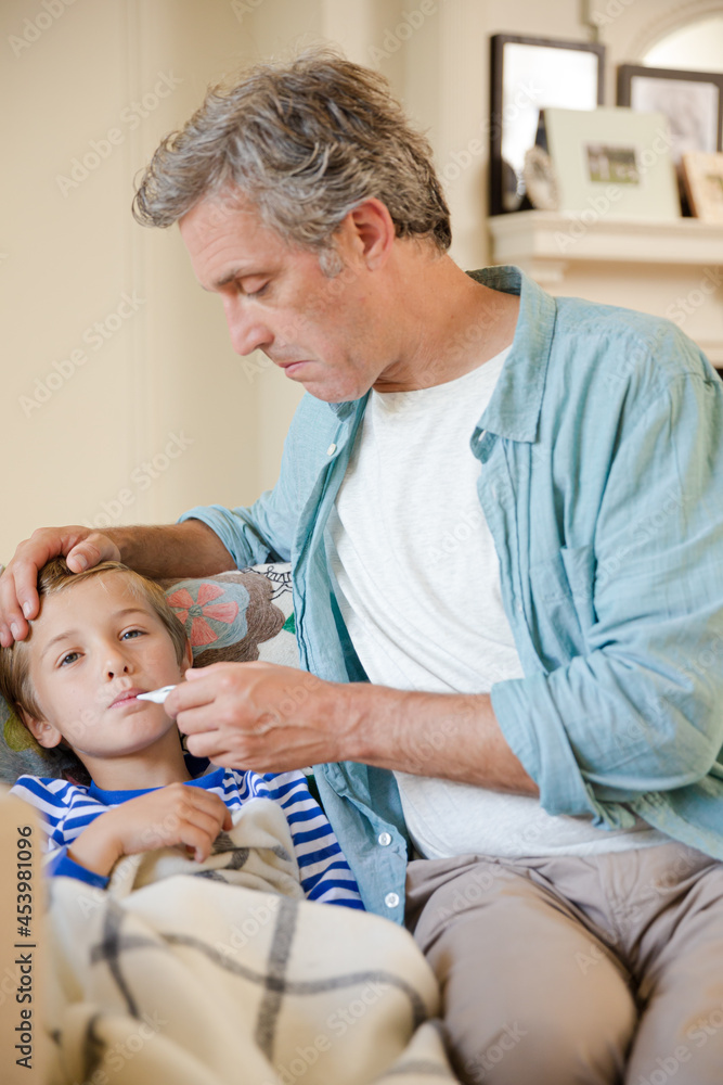 Fototapeta premium Father checking son's temperature