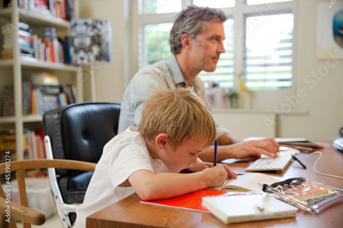 Father and son working in home office