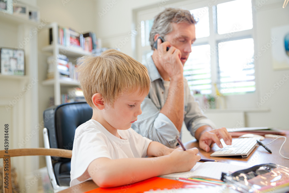 Father and son working in home office Father and son working in home office
