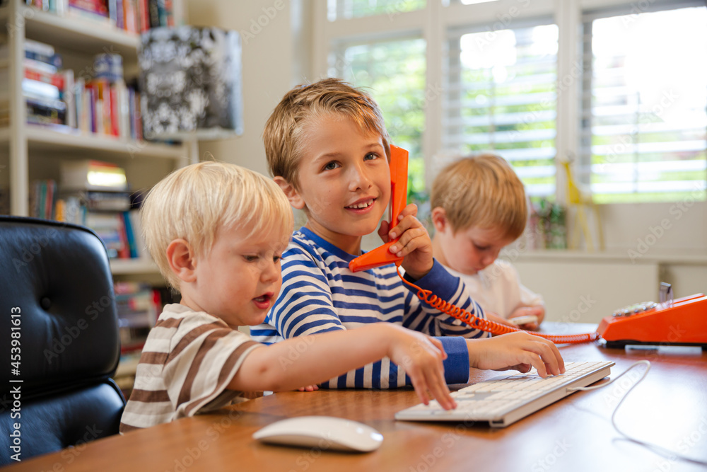Boys using telephone in home office Boys using telephone in home office