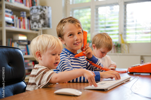 Boys using telephone in home office