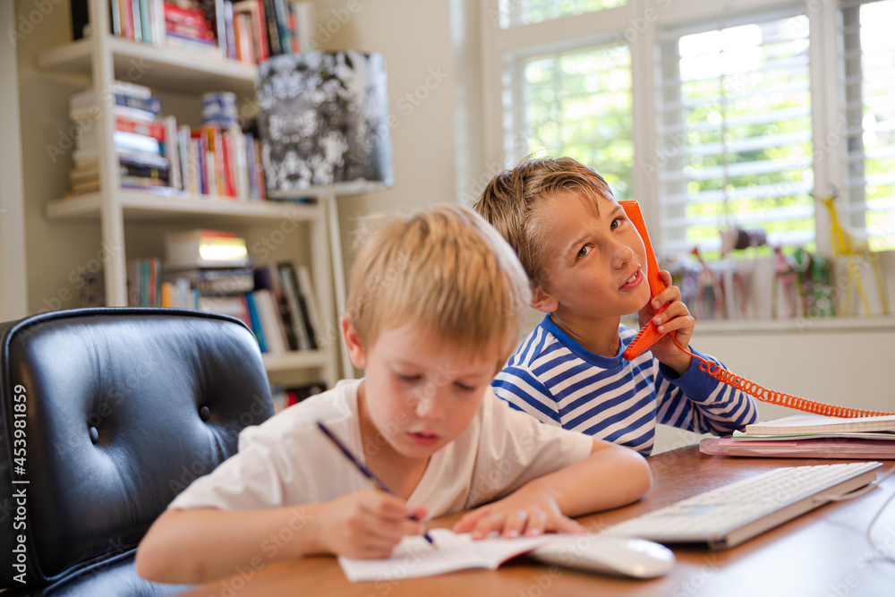 Boys using telephone in home office Boys using telephone in home office